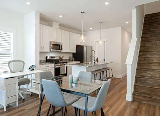 A modern kitchen with a dining table and chairs.