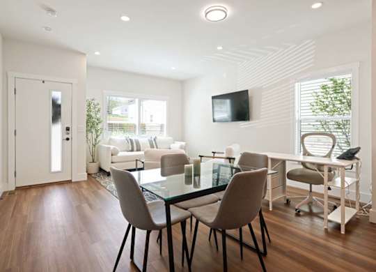 A modern living room with a glass table and chairs.
