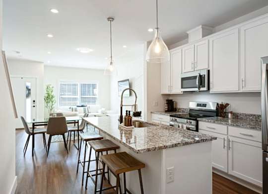 A kitchen with white cabinets and a granite countertop.