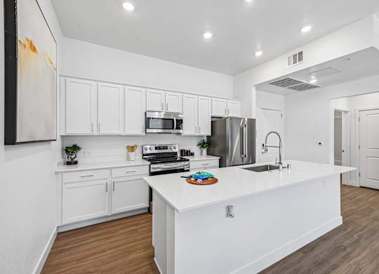 A white kitchen with a large island in the middle.