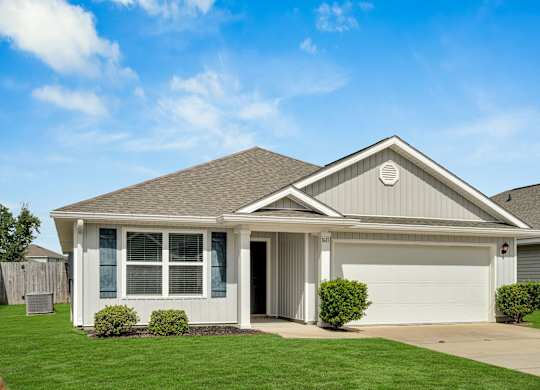 A house with a grey roof and white walls with a garage door.