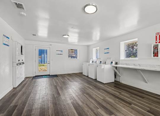 A room with white walls and wooden floors has a blue mat on the floor.