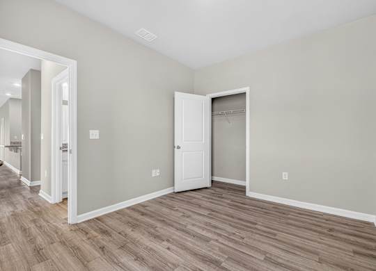 A room with a white door and a wooden floor.
