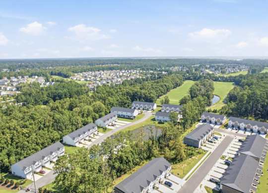 A bird's eye view of a residential area with houses and a parking lot.