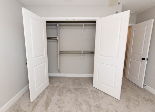 an empty closet in an empty room with two doors