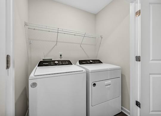 A white laundry room with a washer and dryer.