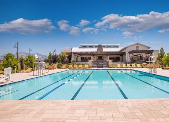 A large outdoor swimming pool with a building in the background.
