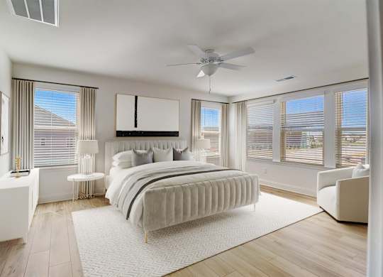 A bedroom with a large bed and a ceiling fan.