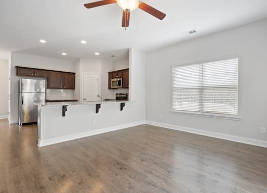 Harris Trail Luxury Townhomes for rent Richmond Hill, GA photo of an empty living room hardwood floors and a ceiling fan