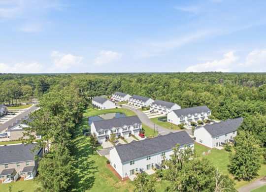 A bird's eye view of a residential area with houses and greenery.