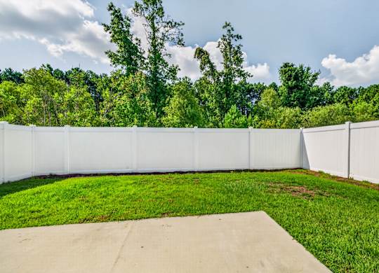 A white fence encloses a green yard.