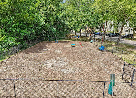 A tennis court surrounded by a fence and trees.
