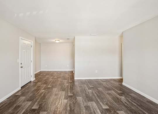 A room with wooden flooring and white walls.
