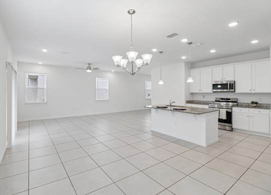 A spacious kitchen with white cabinets and a central island.