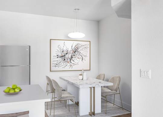 A modern kitchen with a white marble table and chairs.