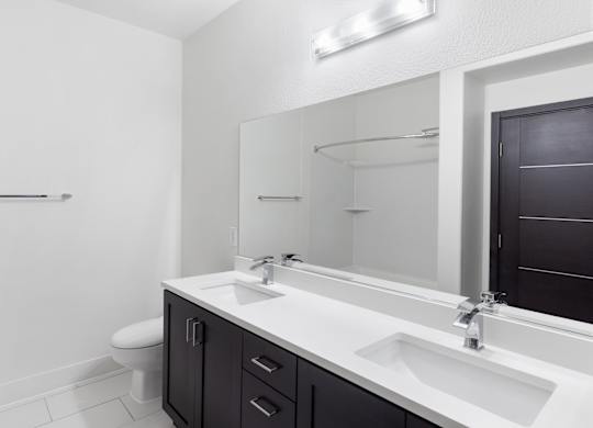 A bathroom with a toilet, sink, and mirror.