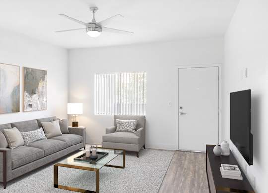 A living room with a grey couch, a coffee table, and a painting on the wall.