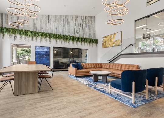 A modern living room with a wooden table and blue chairs.