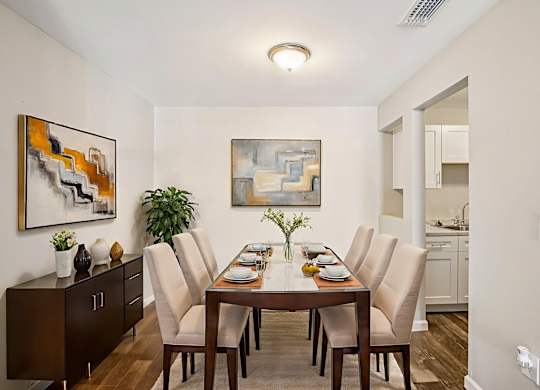A dining room with a wooden table and chairs.