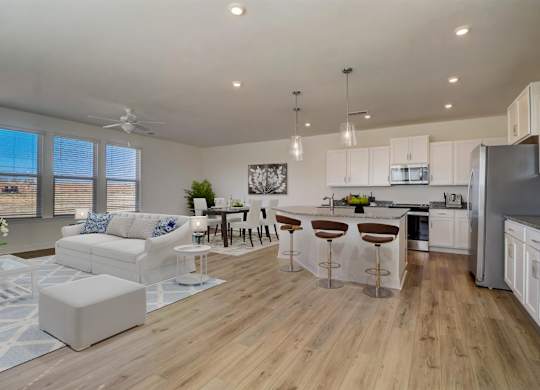 A modern kitchen with white cabinets and a wooden floor.