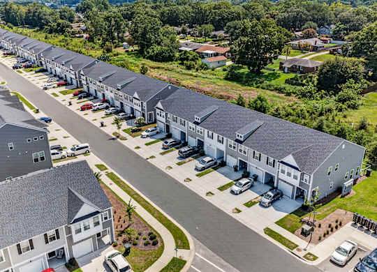 A row of houses with attached garages are shown from an aerial view.