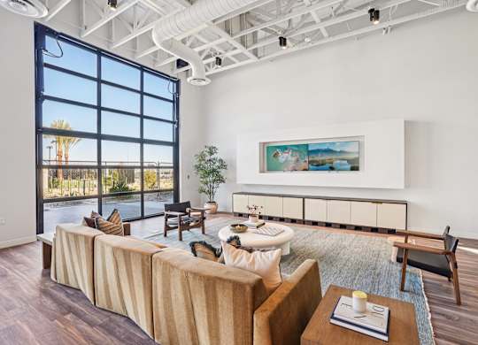 A living room with a large couch and a painting on the wall.