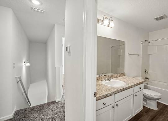 A bathroom with a sink, toilet, and bathtub.