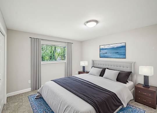 Bedroom with a queen bed, blue accents, and a window view.
