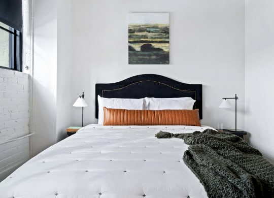 a bedroom with a bed and a painting on the wall