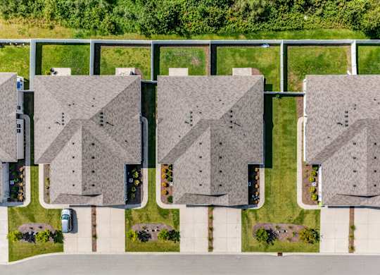 A row of houses with a white fence in front.