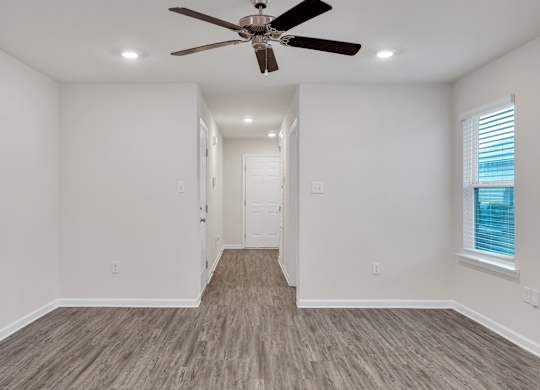 A room with a ceiling fan and lighting fixtures.