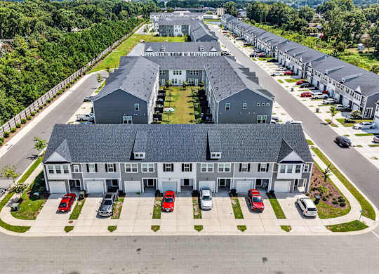 A large grey building with a parking lot in front of it.