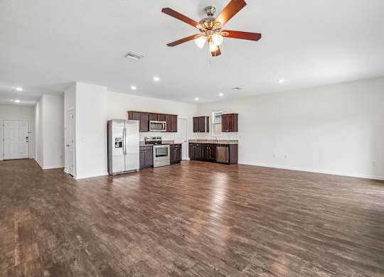 A spacious kitchen with a refrigerator, microwave, oven, and cabinets.