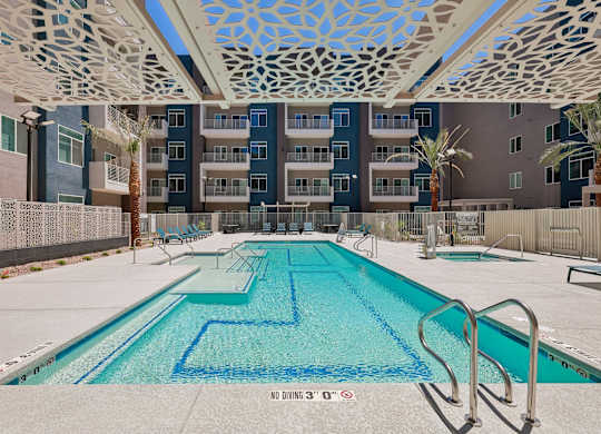 A swimming pool with a blue tiled bottom and a metal ladder on the right side.