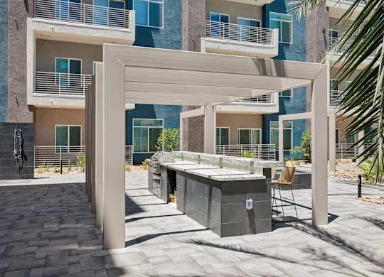 A modern outdoor kitchen area with a grill and a chair.