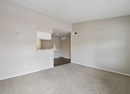 A room with a clock on the wall and a shelf with decorations.