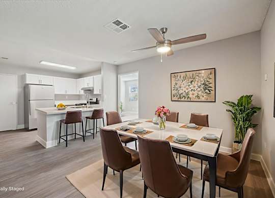 A dining room with brown chairs and a white table.
