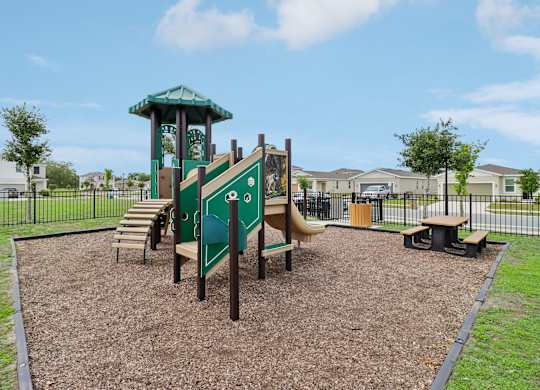 A playground with a green slide and a green and white tower.