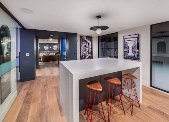 A modern kitchen with a bar area and stools.