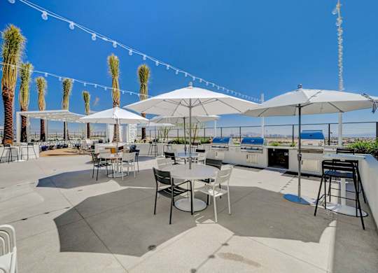 A patio with tables and chairs under umbrellas.