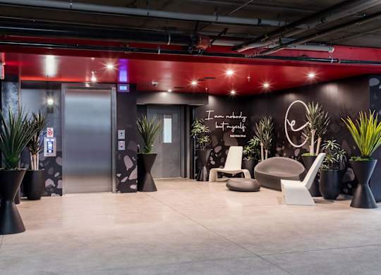 A modern waiting area with a neon sign that says "I am not a robot".