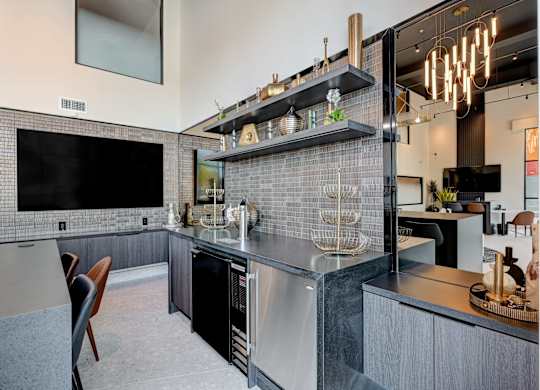 A modern kitchen with a black fridge and a black countertop.