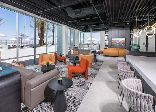 A modern lounge area with a variety of seating options and a view of the outdoors.