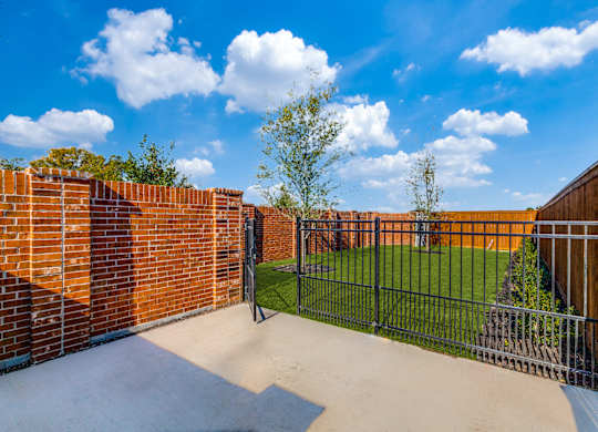 Two-Bedroom Homes for Rent in Houston, TX - East Heights - Dog Park with Green Grass, Trees, and Gated Fence.
