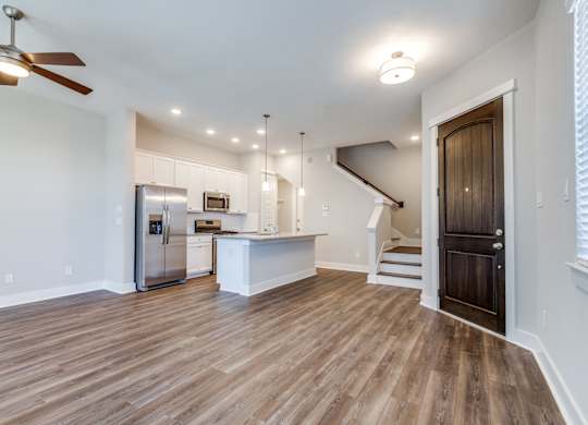 	Houses for Rent in Houston, TX - East Heights - Living Room with Open Floor Plan, Ceiling Fan, Wood-Style Flooring, and Front Door.