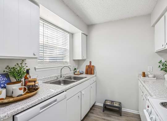 A kitchen with white cabinets and a white stove top oven.