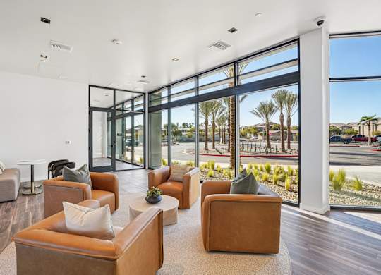 A living room with brown couches and a view of the outdoors.