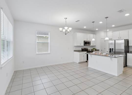 A white kitchen with a large island in the middle.
