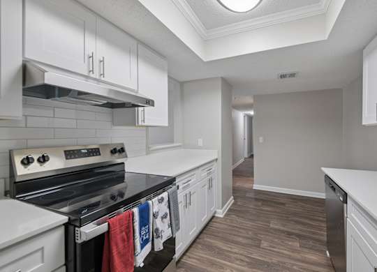 A kitchen with white cabinets and a black stove top oven.