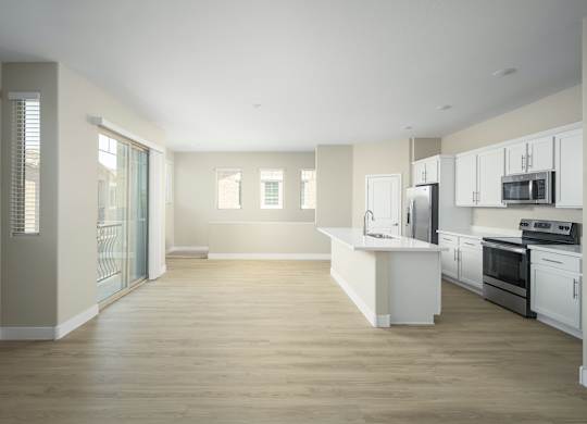 A spacious kitchen with white cabinets and appliances.